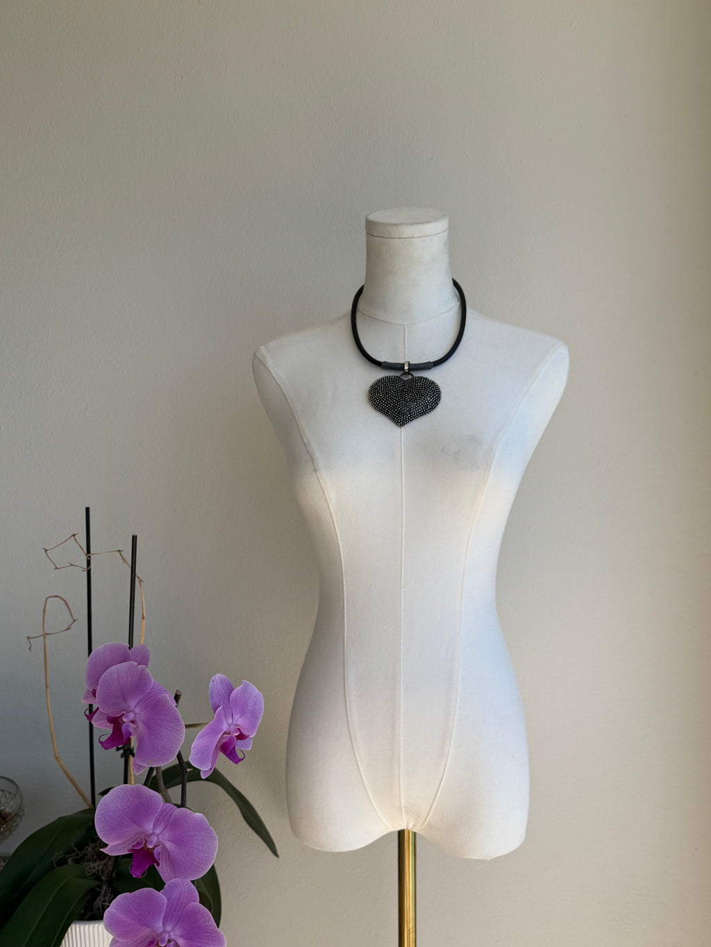 Black beaded heart pendant on sleek collar